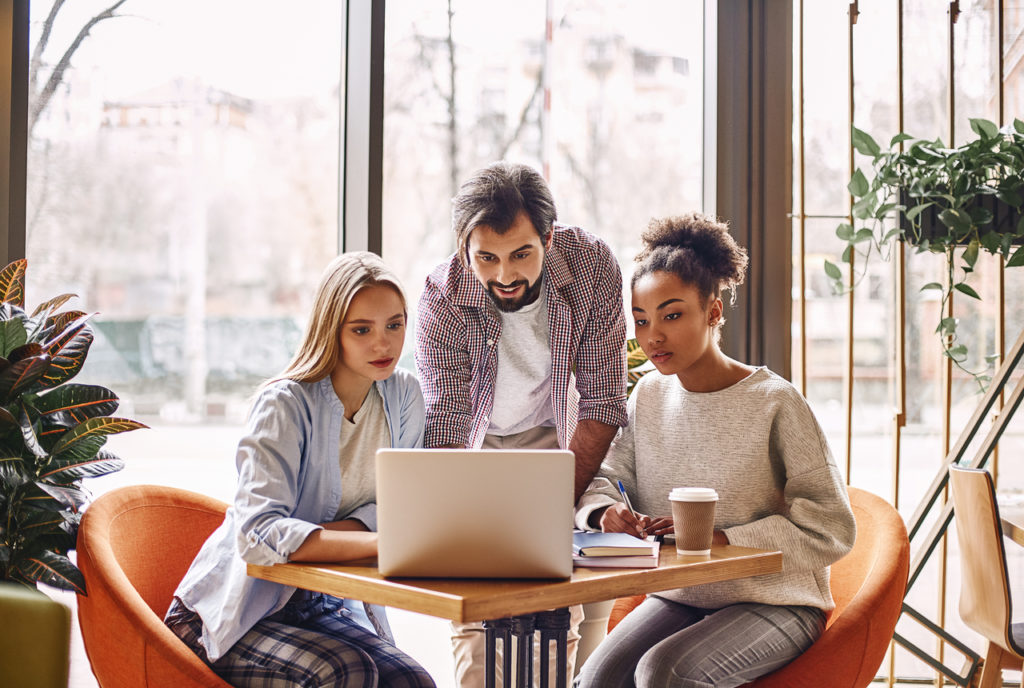 Man and two women work at laptop to grow their business