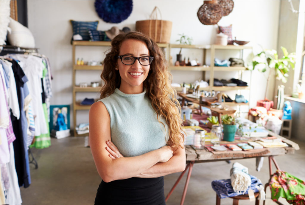 Female business owner smiling as she stands in her successful boutique