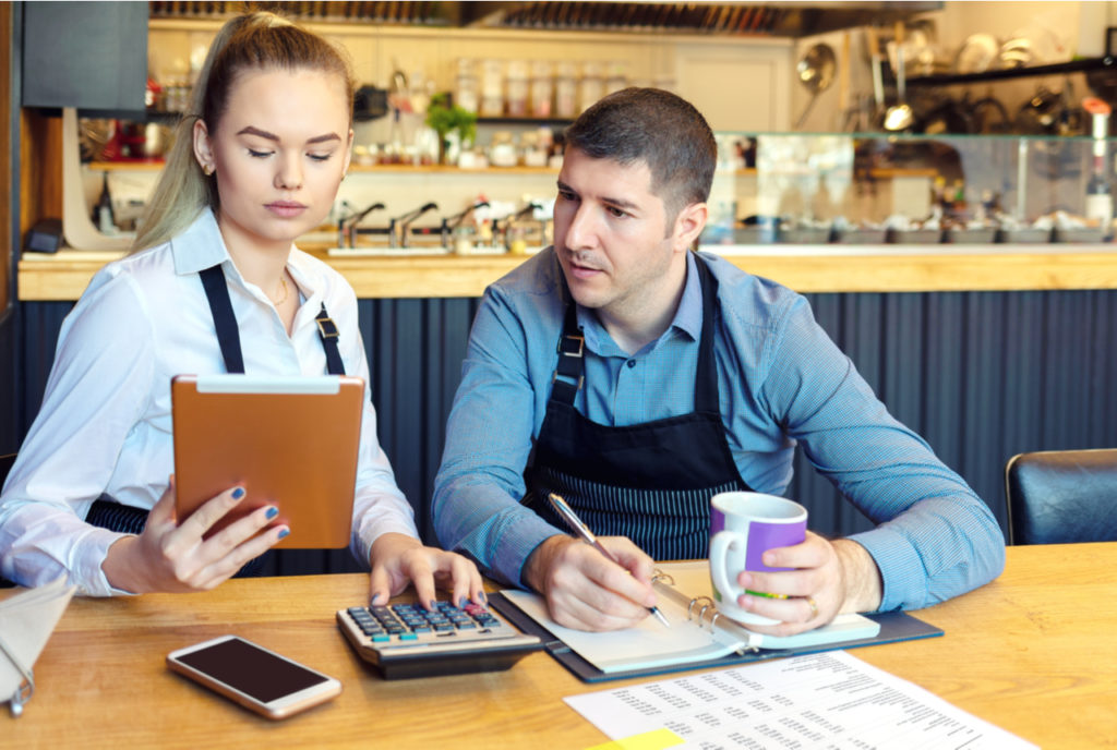 Woman and man work on accounting for their business